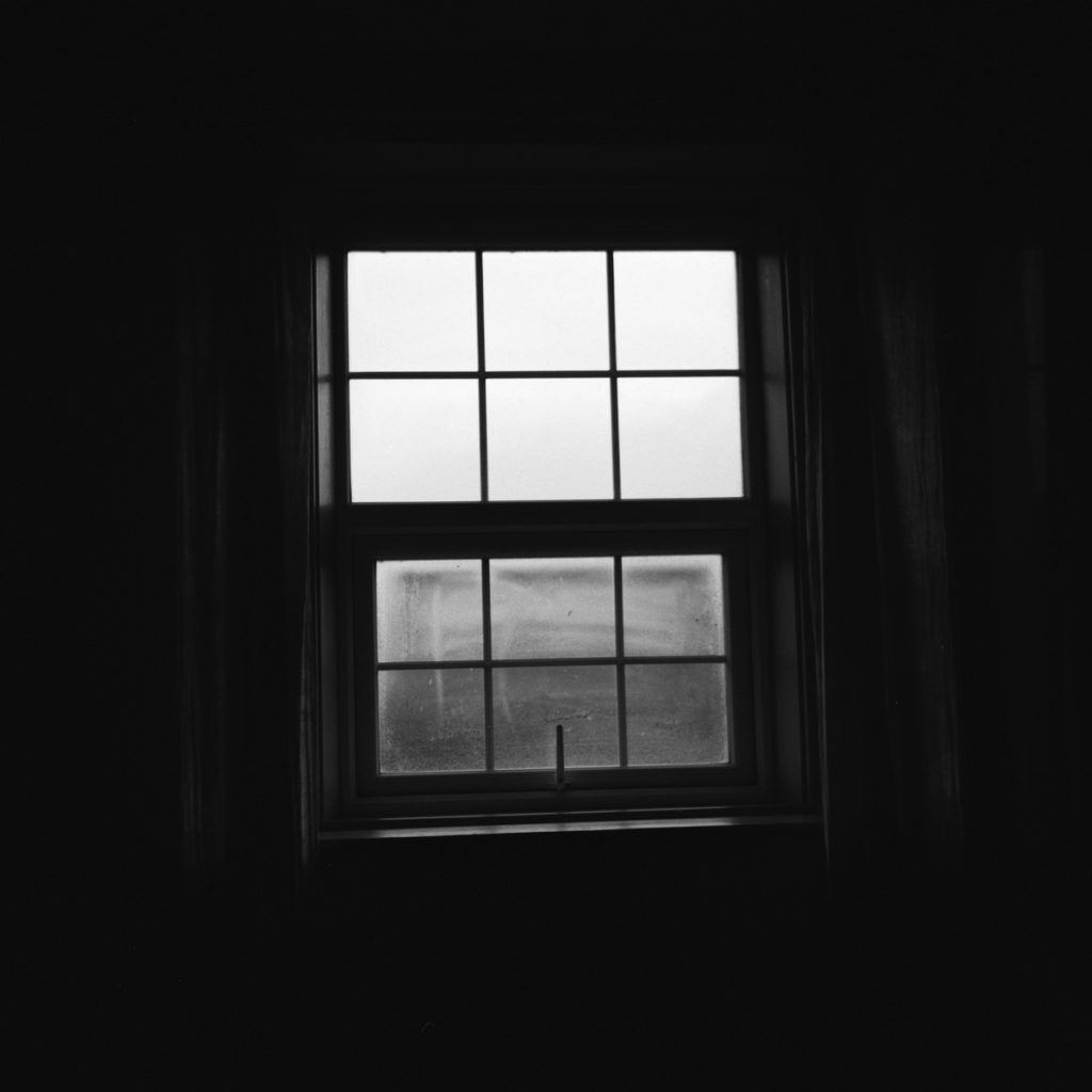 grayscale photo of window with white frame