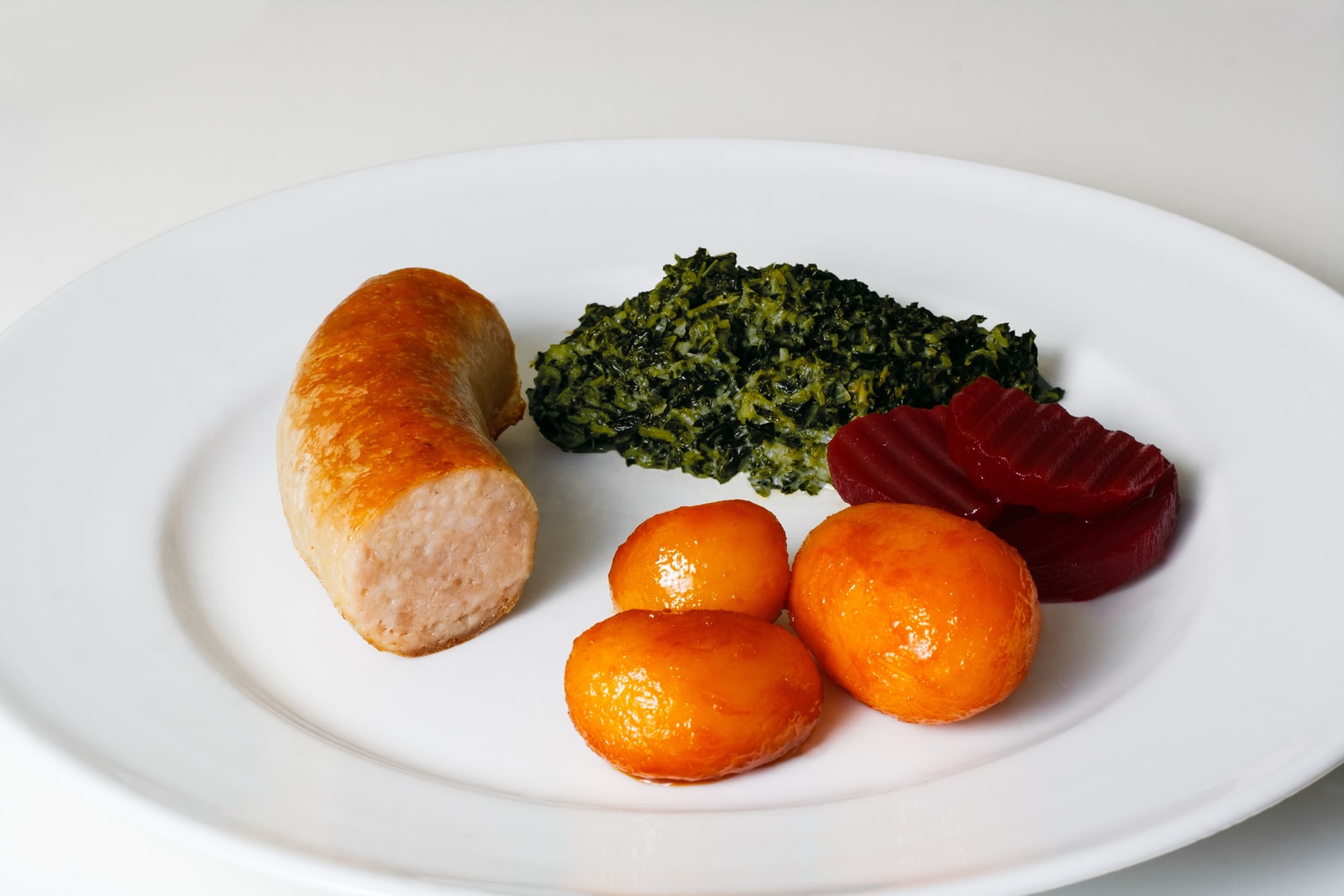 three orange fruits on white ceramic plate