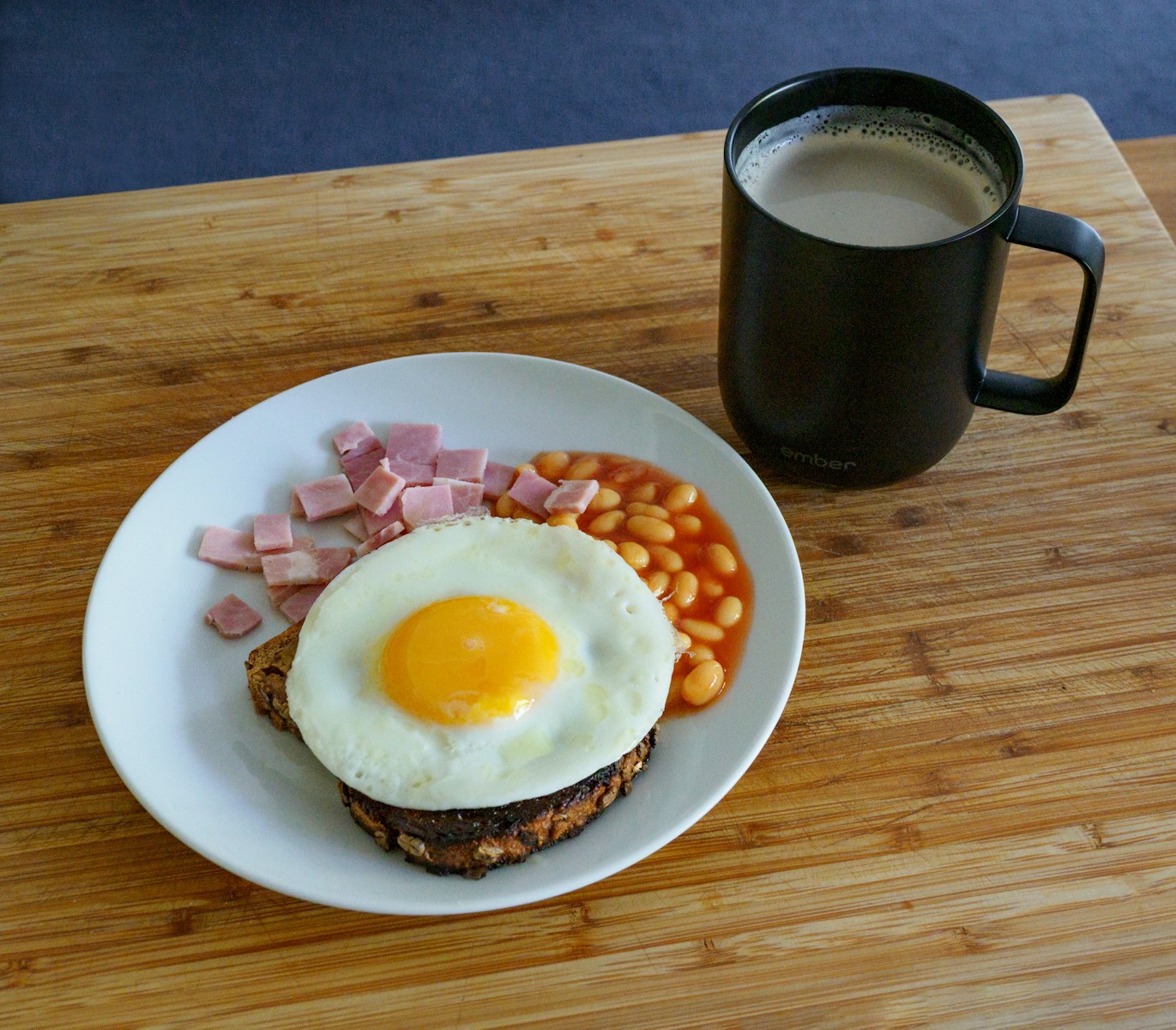 egg on white ceramic plate beside black ceramic mug